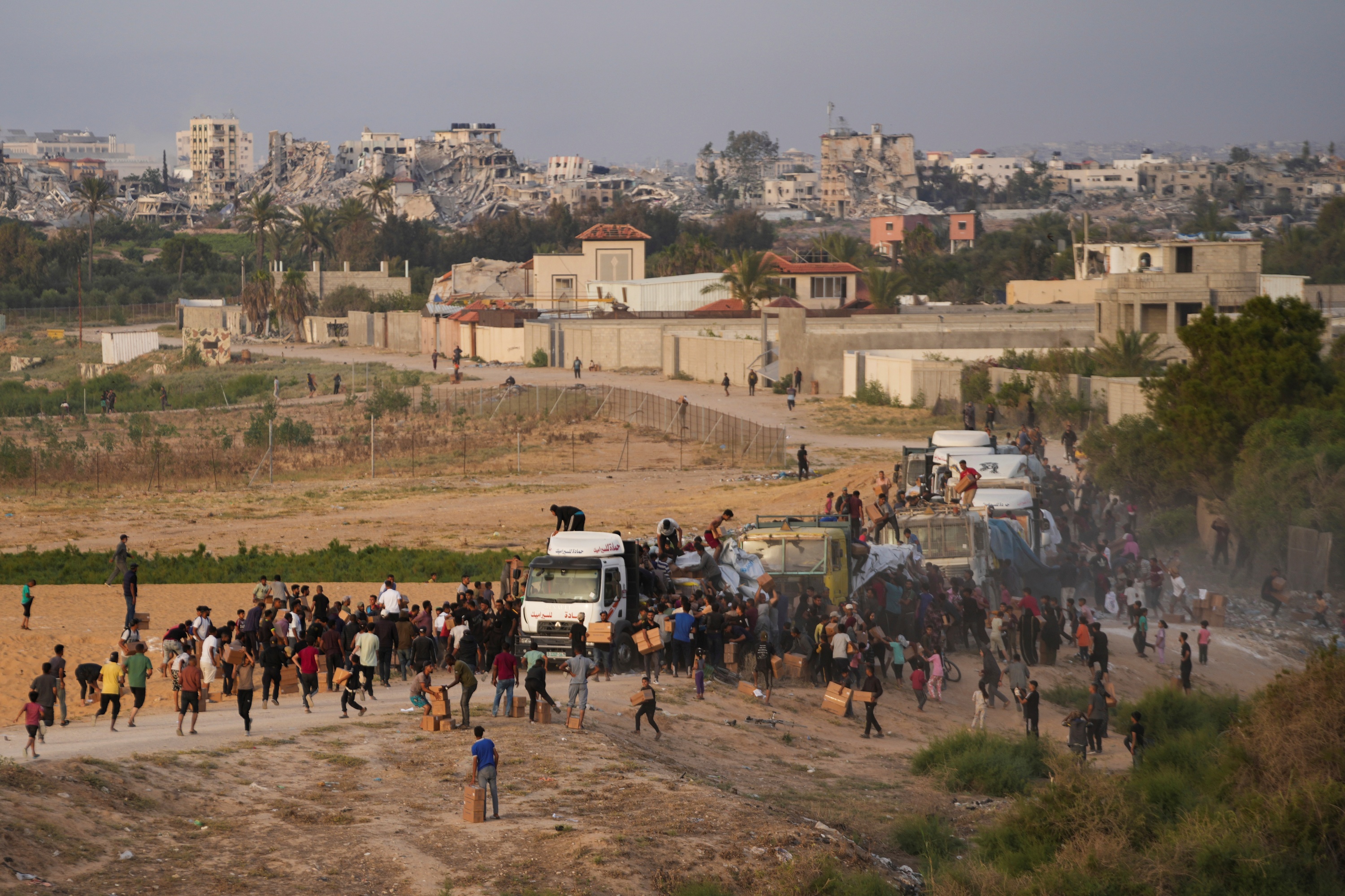 Palestinians are storming trucks loaded with humanitarian aid brought in through a new U.S.-built pier, in the central Gaza Strip, May 18, 2024.