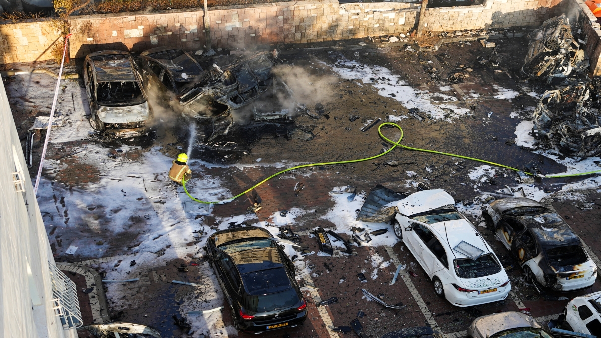 Israeli firefighters extinguish fire after a rocket fired from the Gaza Strip hit a parking lot in Ashkelon, southern Israel, Saturday, Oct. 7, 2023. (AP Photo)