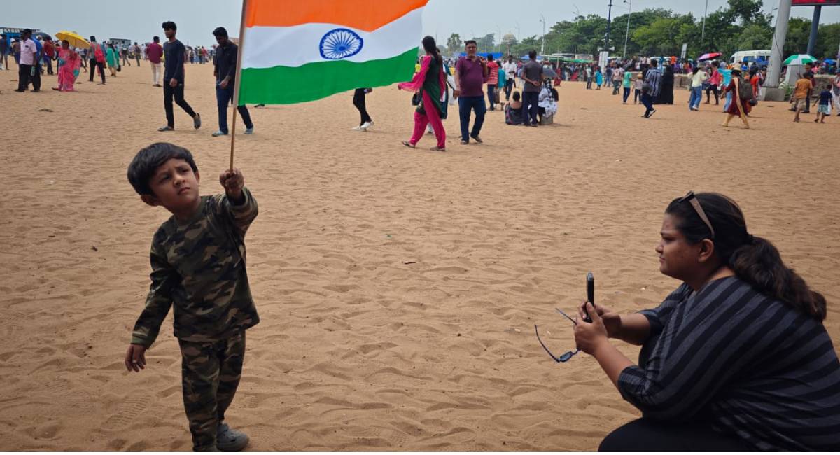 A mother clicks the photograph of her son with a tricolour at Marina Beach