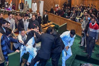 Marshals remove BJP MLAs after a brawl breaks out over a banner on the restoration of Article 370 displayed by Awami Ittehad Party (AIP) MLA and brother of Lok Sabha MP Engineer Rashid, Khurshid Ahmad Sheikh in the Jammu and Kashmir Legislative Assembly session, in Srinagar on Thursday.