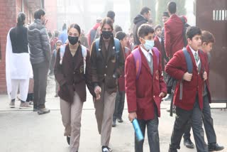 Students leave the school premises on a cold winter day as the schools in Kashmir valley