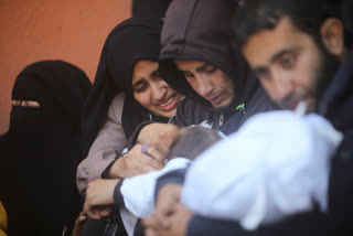 Palestinians mourn for relatives killed in the Israeli bombardment of the Gaza Strip outside a morgue in Khan Younis on Sunday, Jan. 7, 2024. (AP Photo/Mohammed Dahman)