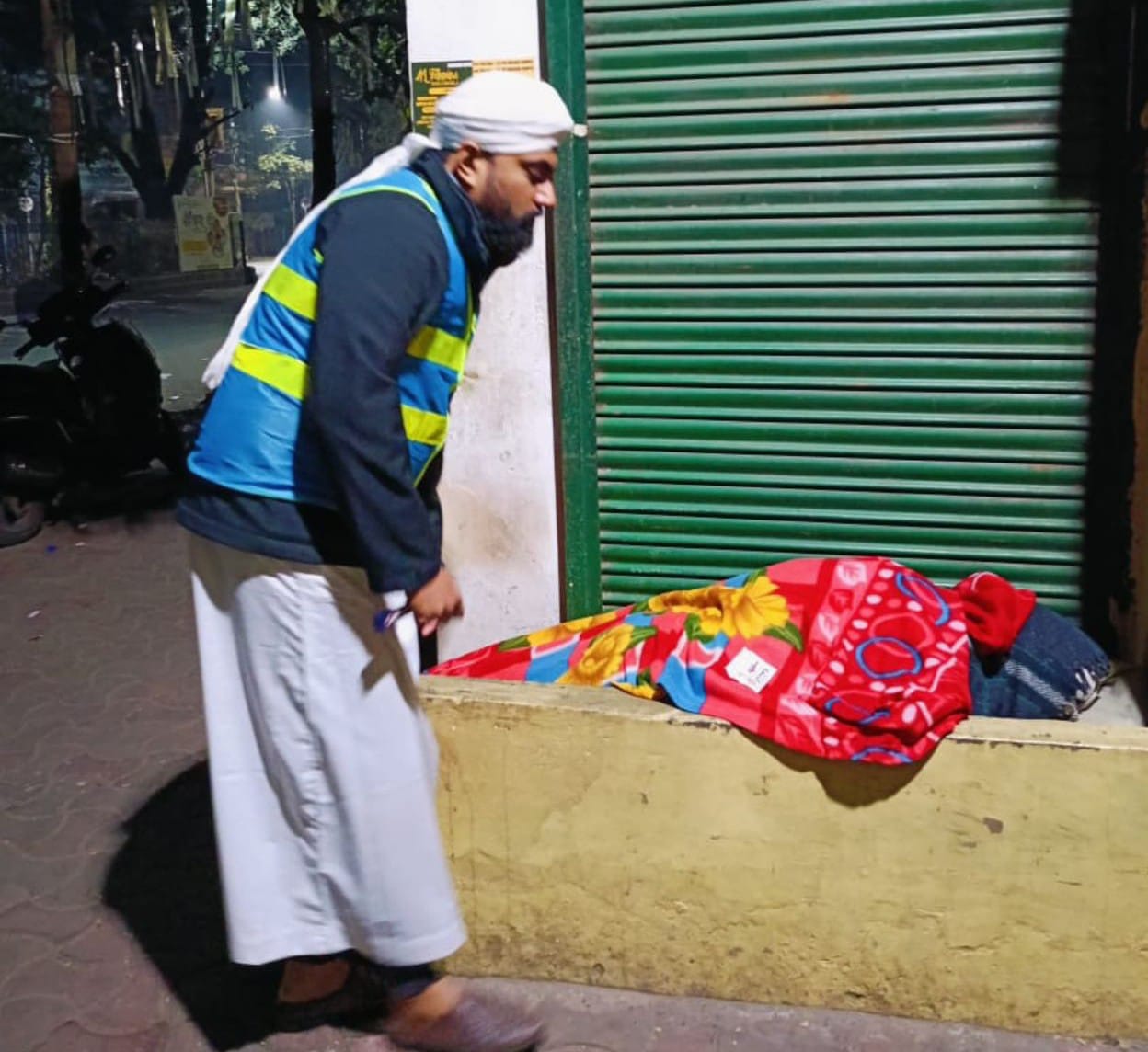 غریب نواز ریلیف فاؤنڈیشن کے ارکان فٹ پاتھ پر سو رہے لوگوں کو کمبل اڑھاتے ہوئے