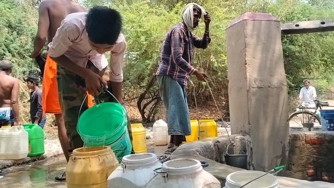 कुएं से पानी भरते ग्रामीण