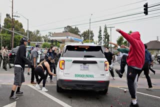 Protesters kick the side of a Border Patrol vehicle during a demonstration over the dozens detained in an operation by federal immigration authorities a day earlier in Paramount section of Los Angeles Saturday, June 7, 2025.