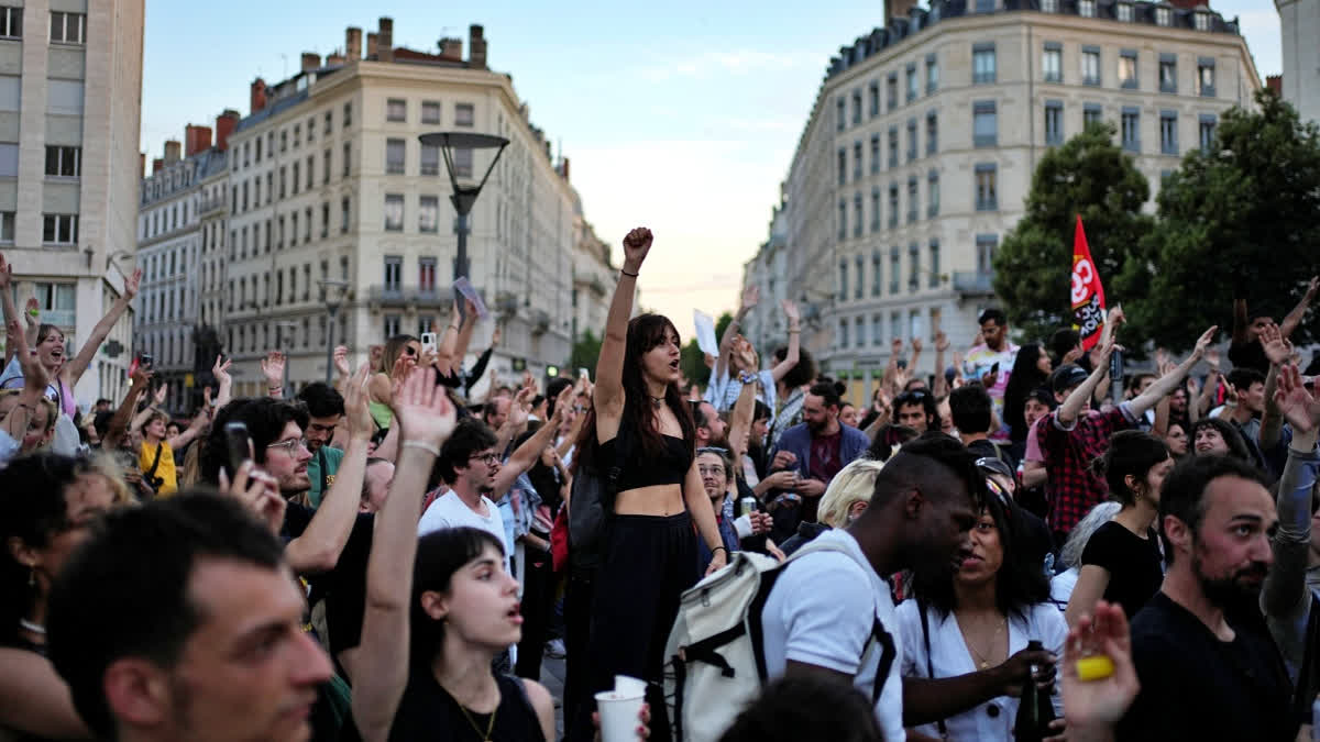 People stand in a square as they react to projected results after the second round of the legislative elections, in Lyon, central France, Sunday, July 7, 2024.