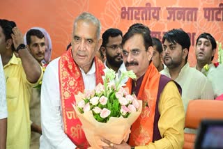 Congress-turned-BJP MLA Ramniwas Rawat (L) congratulated by State BJP president VD Sharma after he takes oath as Minister