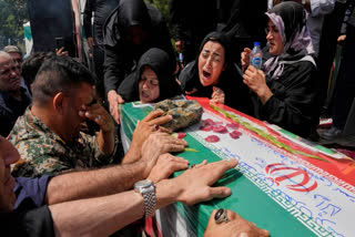 Relatives mourn over the flag-draped coffin of Mahan Setareh, a member of the paramilitary Basij force who was killed in Israeli attacks, during his funeral ceremony in Tehran, Iran, Thursday, June 26, 2025.