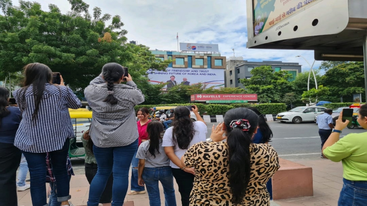 People taking photos of hoardings showing the friendship between the two countries