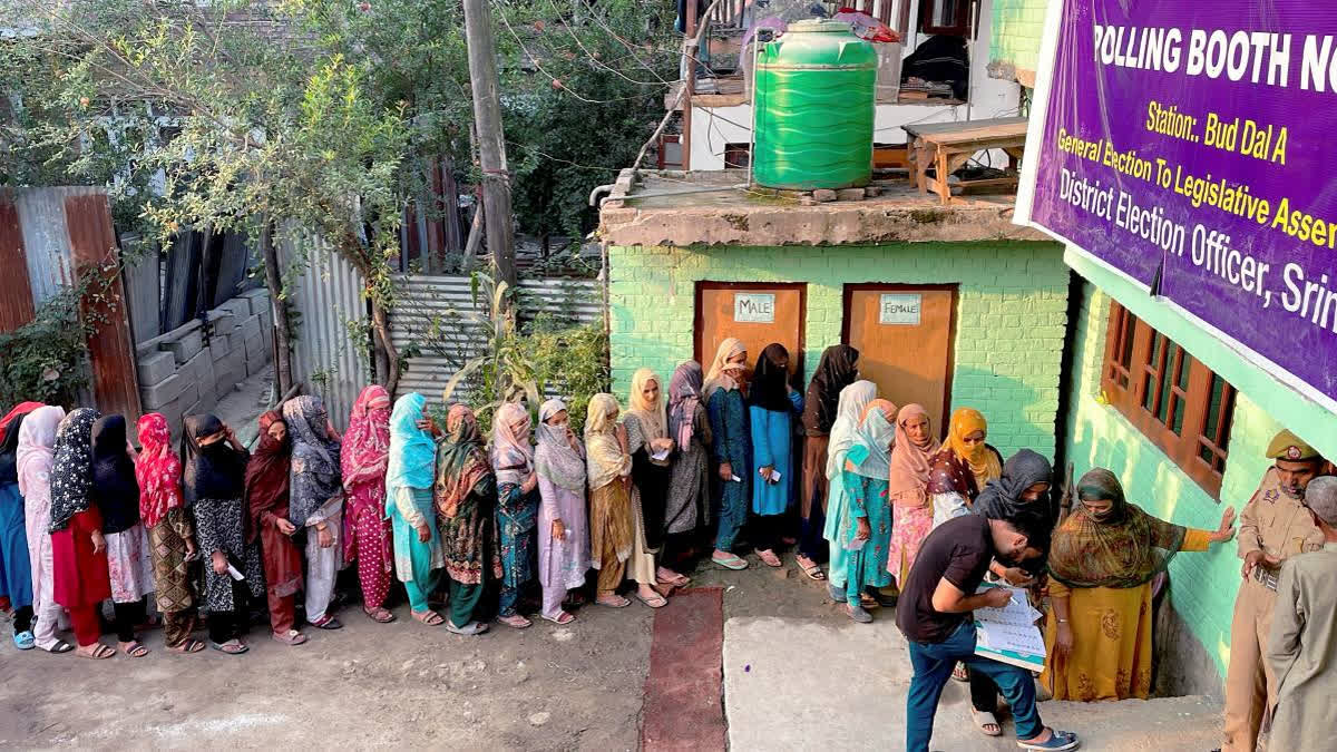 People Queue up at a polling station in Srinagar during JK assembly elections