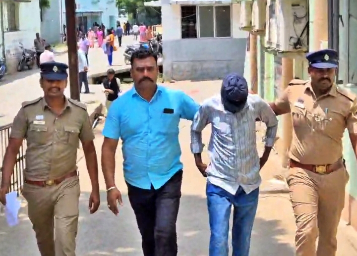 காவலாளியை போலீசார் கைது செய்து அழைத்துச் செல்லும் காட்சி