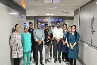 Rajasthan man (M) with his toddler son in his lap poses with the doctors at the Civil Hospital in Gujarat after a corn grain is removed from the boy's lung through a complex surgical procedure. A corn grain had accidentally got stuck in the child's windpipe due to which the his breathing suddenly increased. The increasing pressure caused a hole in the child's lungs