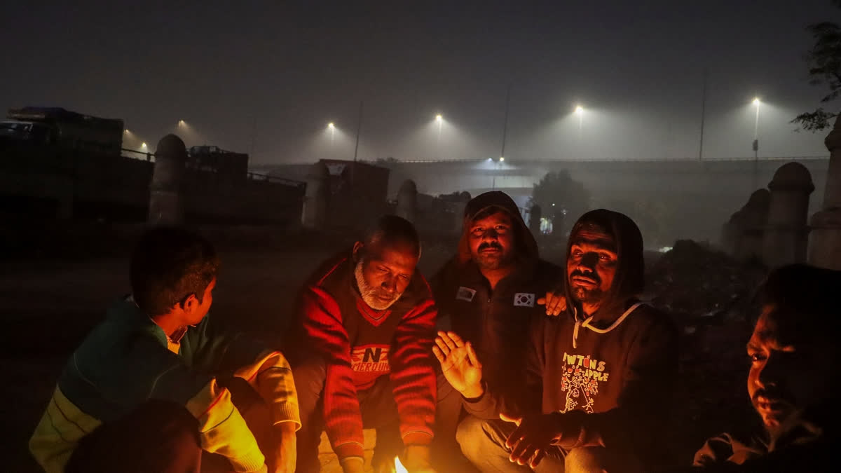 People sit around a bonfire to keep themselves warm on a cold winter evening, in New Delhi, Thursday, Jan. 9, 2025.