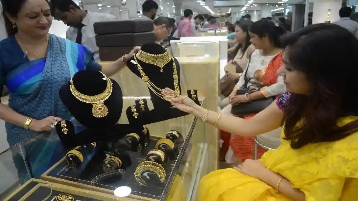 தங்க நகையை வாடிக்கையாளர் பார்ப்பது போன்ற காட்சி