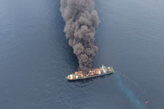 In this image posted by X/@IndiaCoastGuard, Monday, June 9, 2025, thick black smoke billows from Singapore-flagged container vessel MV WAN HAI 1503 following an explosion, about 130 nautical miles northwest of Kerala coast.
