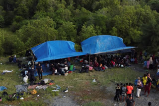 Ethnic Rohingya people take shelter under a a tent after landing on a beach in Kuala Besar, North Sumatra, Indonesia, Sunday, Dec. 31, 2023.