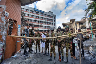 Army personnel stand guard in front of Jatrabari Police Station, that was vandalized and set on fire, in Dhaka, Bangladesh, Friday, Aug. 9, 2024.