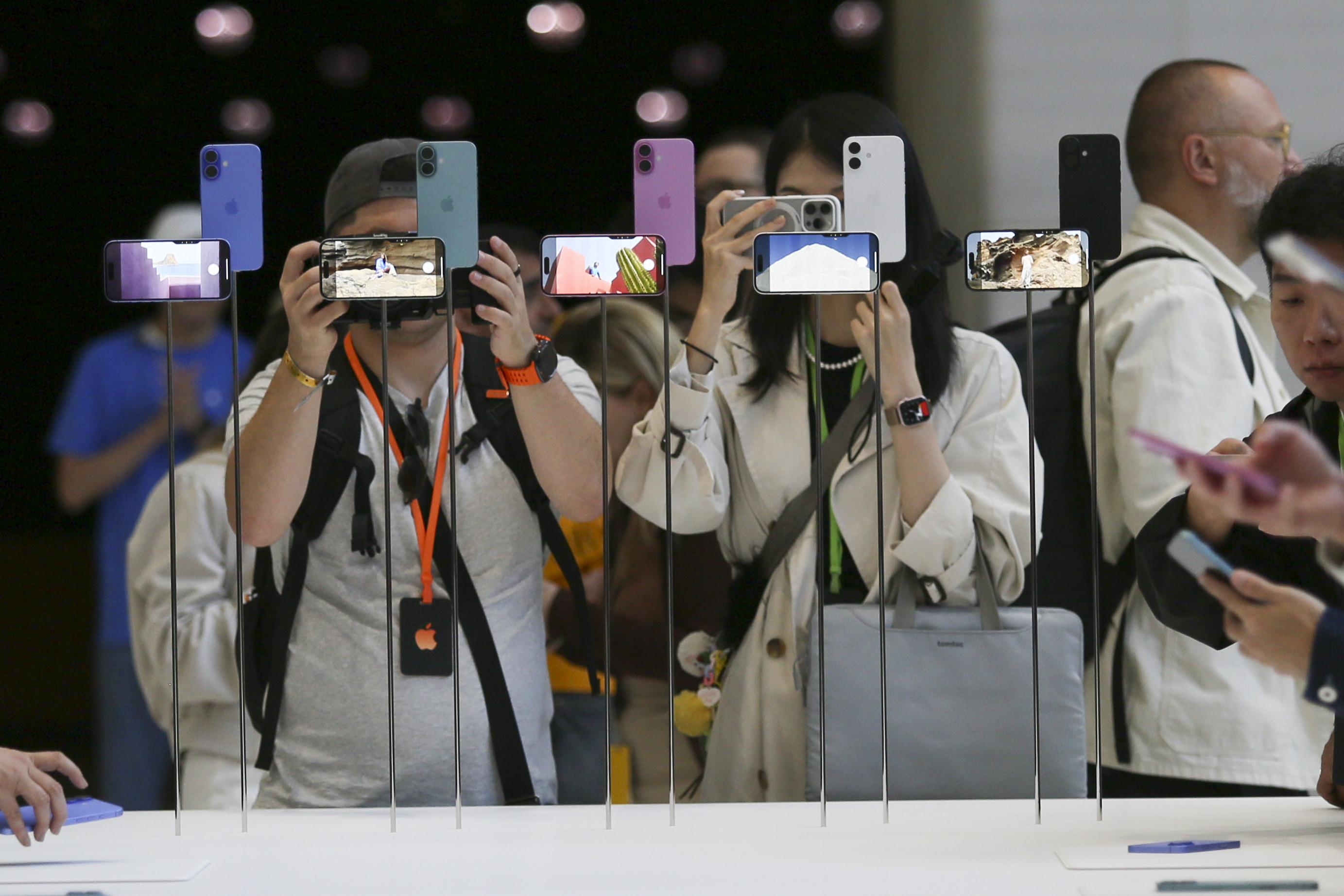 Attendees take a closer look at the Apple iPhone 16 during an announcement of new products at Apple headquarters at the launch