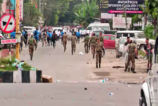 Security personnel disperse student protesters during their march to Raj Bhavan demanding the removal of DGP and Security Advisor over the situation in the state, in Imphal on Monday.