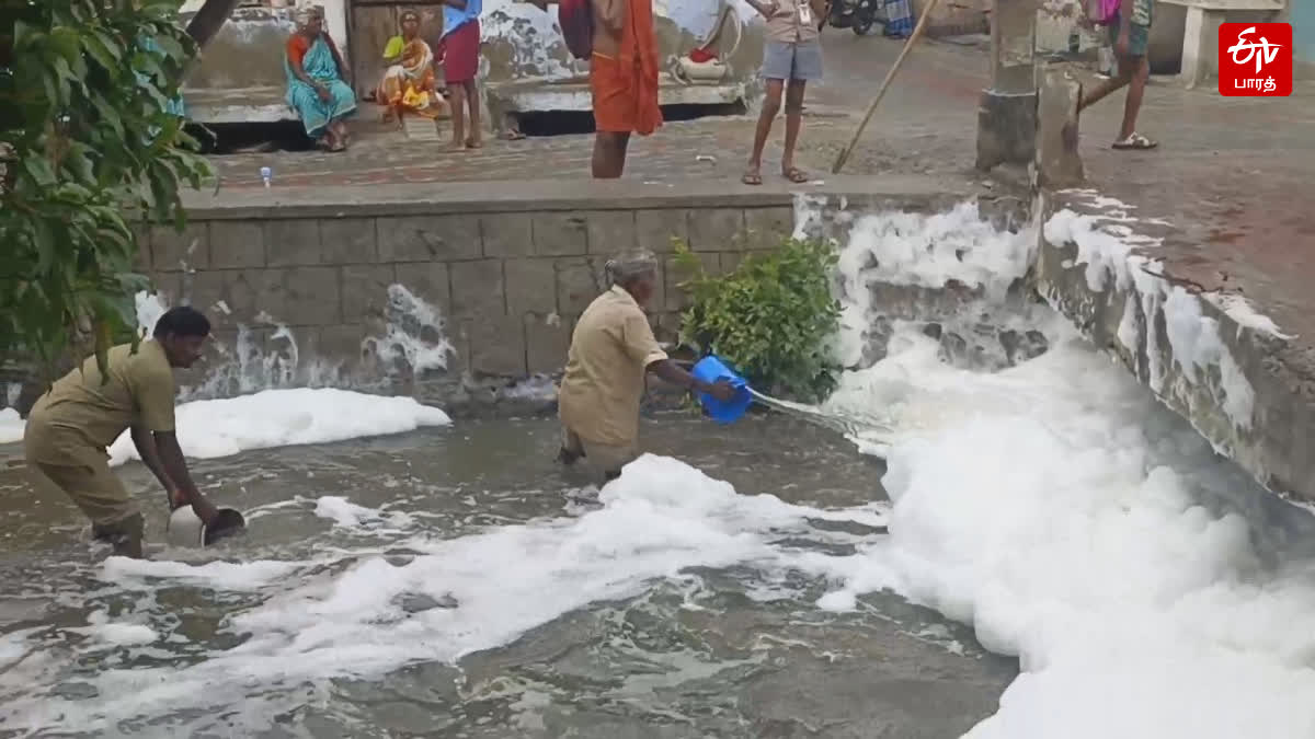 தூத்துக்குடியில் கண்மாயில் செல்லும் வெண் நுரையை தண்ணீர் ஊற்றி அகற்றிய தூய்மை பணியாளர்கள்