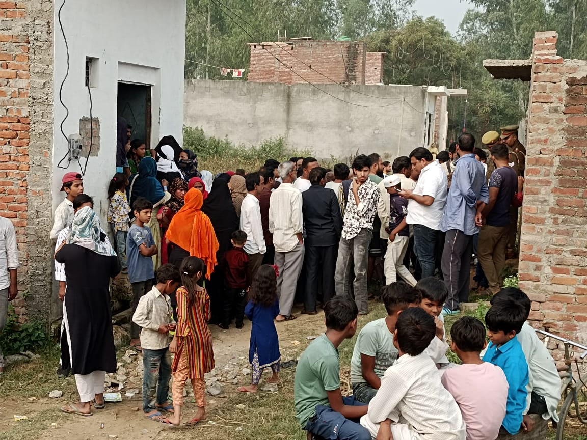 Locals gather outside the house of a couple, who along with their son were stabed to death in Bijnor, Uttar Pradesh. a scrap dealer, his wife and their teenage son were stabbed to death with knives by unidentified assailants while they were sleeping inside their house in Uttar Pradesh's Bijnor