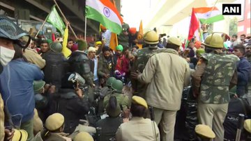 Police officials sit on road in Nangloi to block the area where farmers holding tractor parade have reached