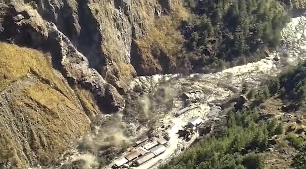 This frame grab from video provided by KK Productions shows a massive flood of water, mud and debris flowing at Chamoli District