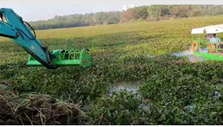 The weed aggregator pushes the weed towards  dyke and the Hitachi drags and	 piles it on the bund