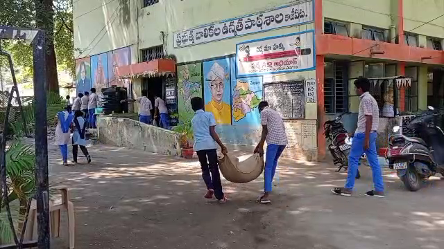 Students carry rice bags at Kazipet Government High School in Warangal Urban District.