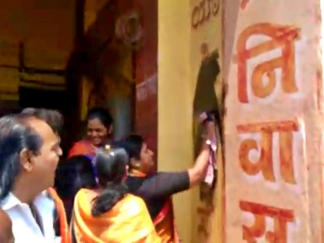 Shiv Sena workers in black ink on Kannada letters on top of stores