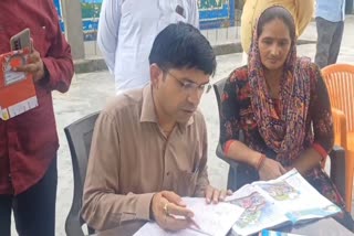 District Magistrate Dr. Rajendra Pansiya checking the text books of students during inspection of a school in Sambhal