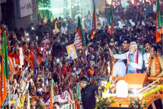 PM Modi waves to supporters at a roadshow in Ranchi