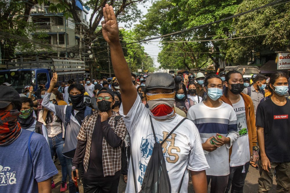 Anti-coup protesters gesture with a three-fingers salute, a symbol of resistance during a demonstration in Yangon