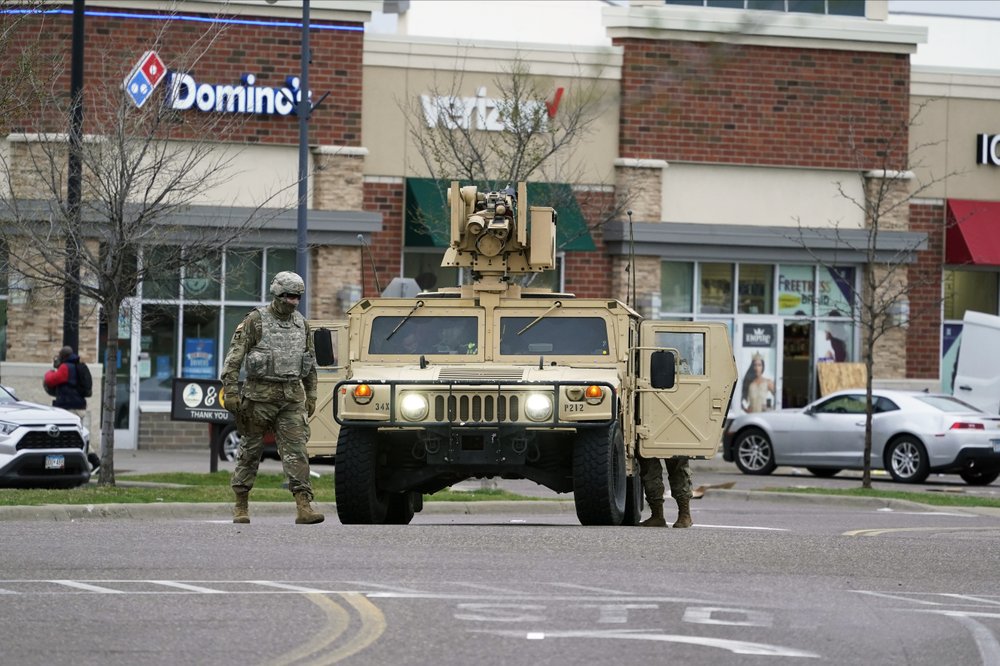 A National Guard soldier maintain watch and directs traffic at a shopping center in Brooklyn Center