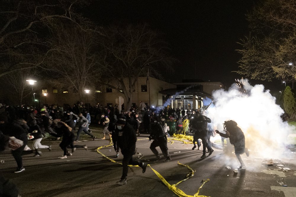 eople run as police attempt to disperse the crowd at the Brooklyn Center Police Department, late Sunday