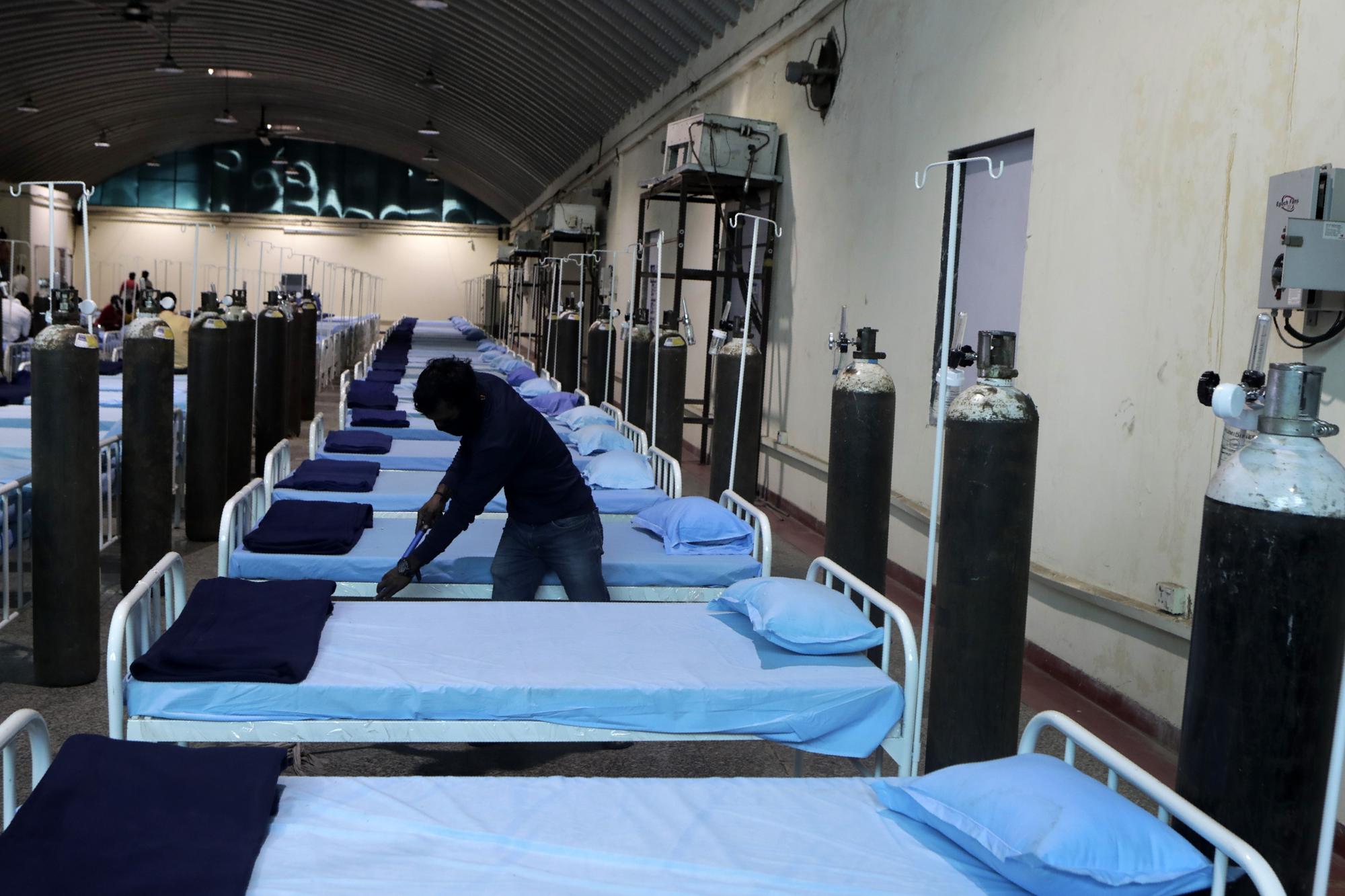 A worker cleans a newly set up C0VID- 19 hospital at Science Center in Mumbai