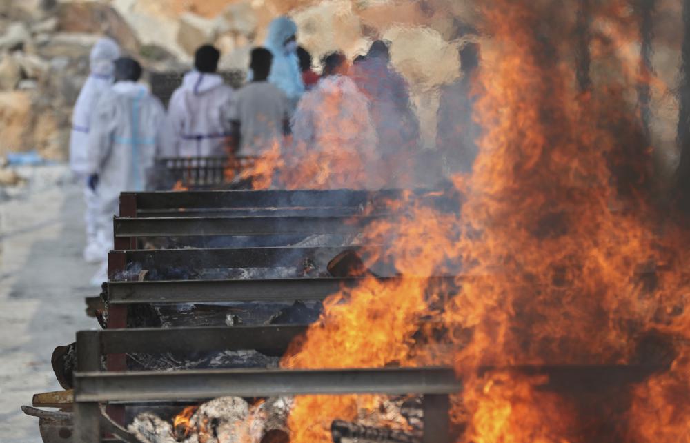 Family members perform last rites of a person who died of COVID-19