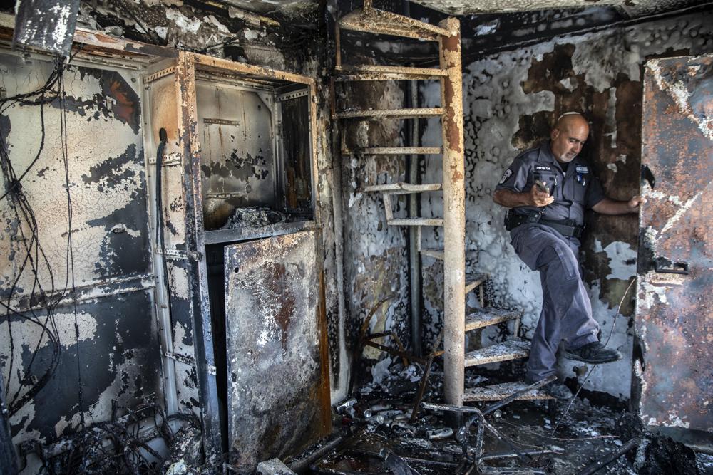 Avi Korkas, a municipality worker, examines the damages of a municipality office in charge of an outdoor food market, that was torched after a night of violence between Israeli Arab protesters