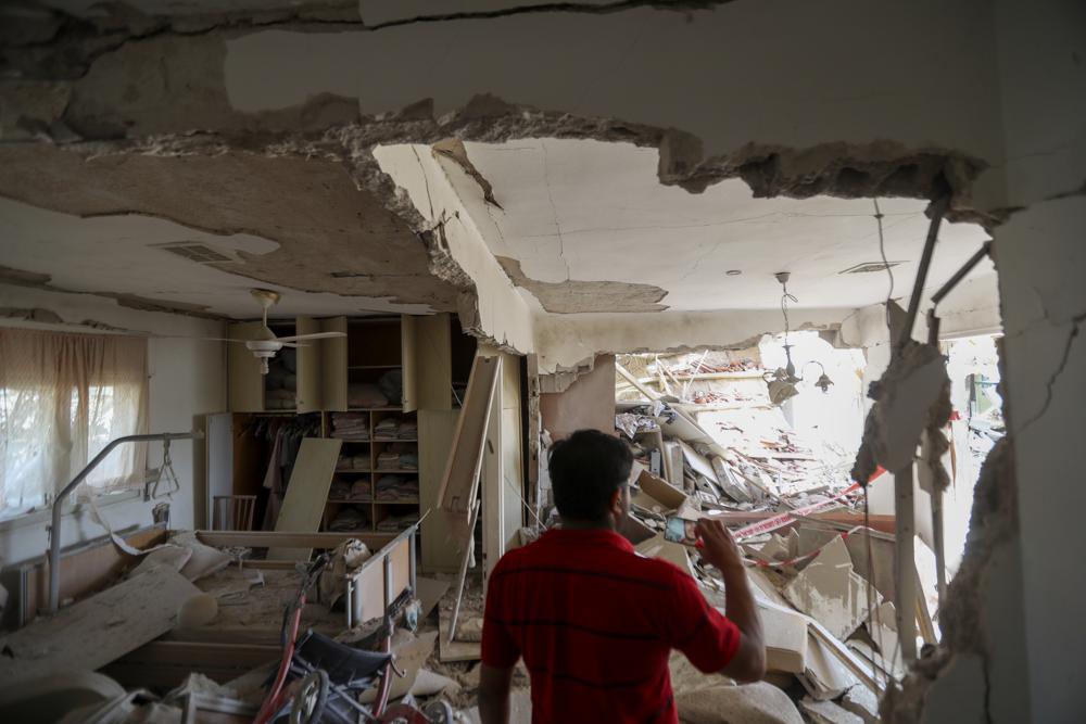 A man inspects the heavily damaged house after it was hit by a missile fired from the Gaza Strip, in the southern Israeli city of Ashkelon