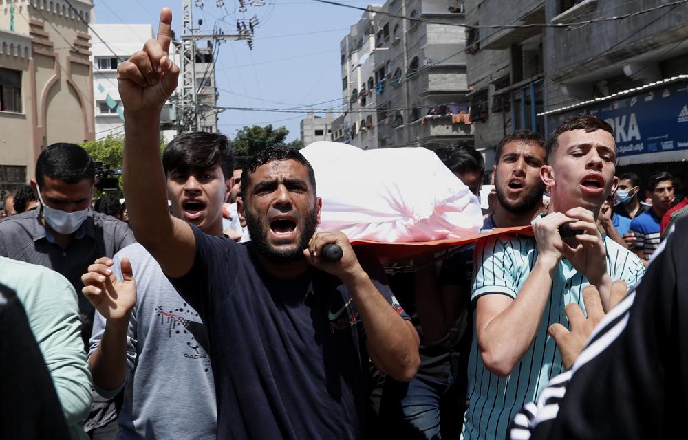 Palestinian mourners carry the body of 11-year-old Hussain Hamad, who was killed by an explosion during the ongoing conflict between Israel and Hamas