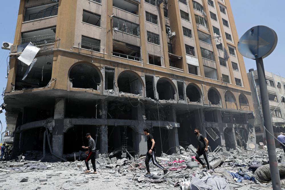 People inspect the rubble of a damaged building which was hit by an Israeli airstrike, in Gaza City