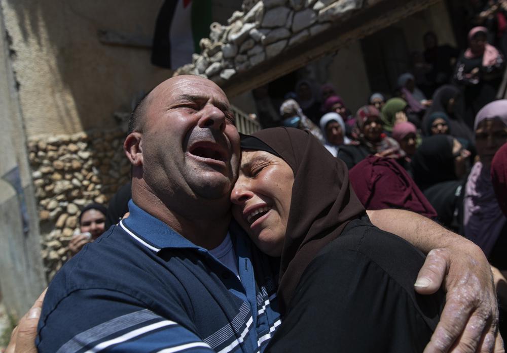 Palestinian mourners cry while taking a last look at the body of Mohammad Daraghmeh at the family house during his funeral in the West Bank village of Lubban, near Nablus