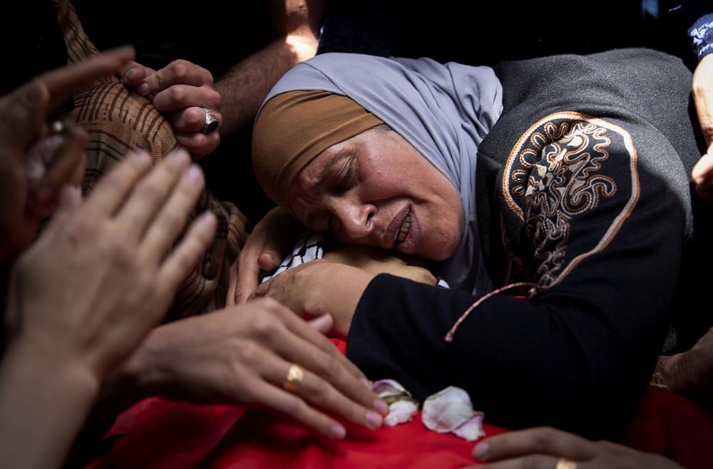 A Palestinian woman mourns over her son Rasheed Abu Arra, who was killed in clashes with Israeli forces, during his funeral in the Village of Aqqaba near the West Bank town of Tubas