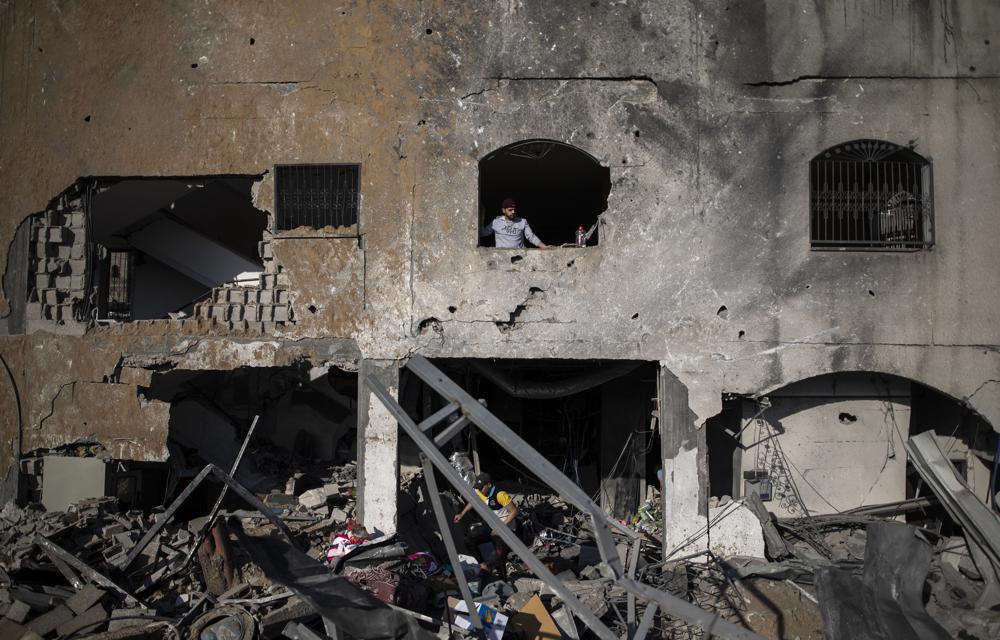 Palestinians inspect their destroyed home after being hit by Israeli airstrikes in town of Beit Lahiya, northern Gaza Strip,