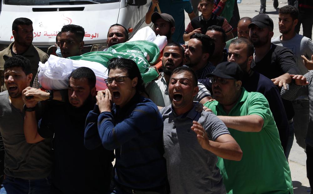 Mourners chant Islamic slogans while carrying the body of Awad Abu Selmiya, during a funeral of thirteen Hamas militants outside a mosque in Gaza Cit