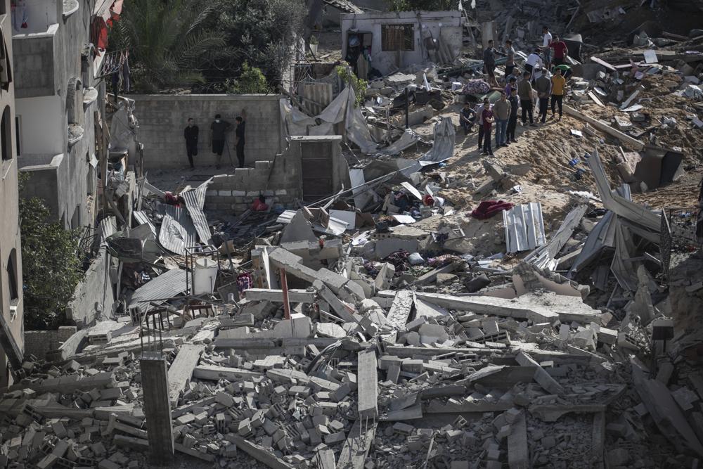 Palestinians inspect the rubble of their destroyed homes after being targeted by Israeli airstrikes in town of Beit Lahiya, northern Gaza Strip