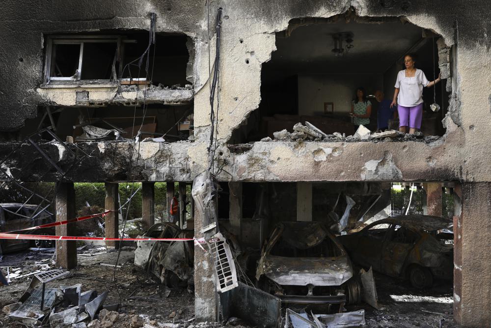 Palestinians inspect their destroyed home after being hit by Israeli airstrikes in town of Beit Lahiya, northern Gaza Strip