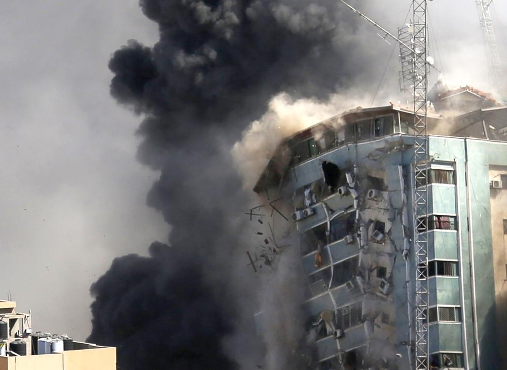 The building housing the offices of The Associated Press and other media in Gaza City collapses after it was hit by an Israeli airstrike