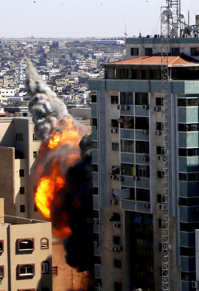 The building housing the offices of The Associated Press and other media in Gaza City collapses after it was hit by an Israeli airstrike