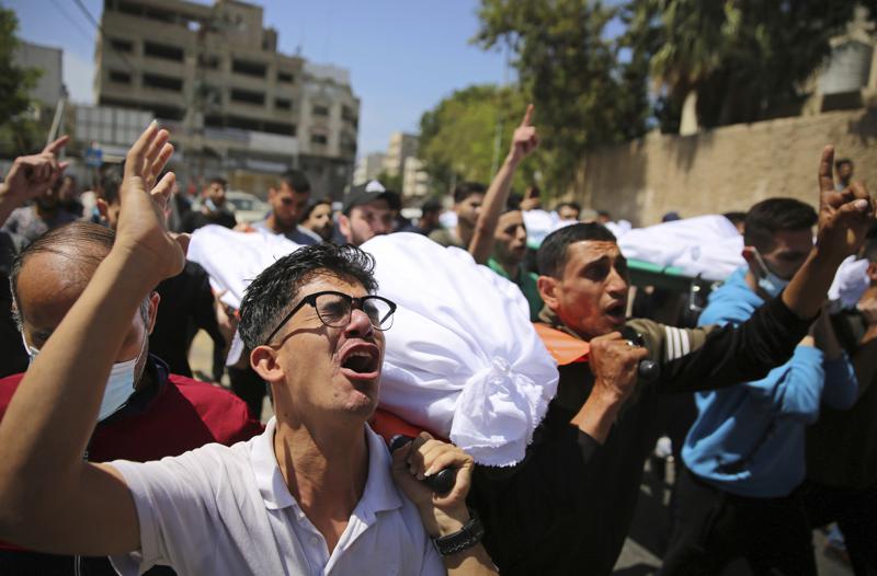 Mourners carry the the bodies of Palestinians who were killed in overnight Israeli airstrikes that hit their homes, during their funeral in Gaza City